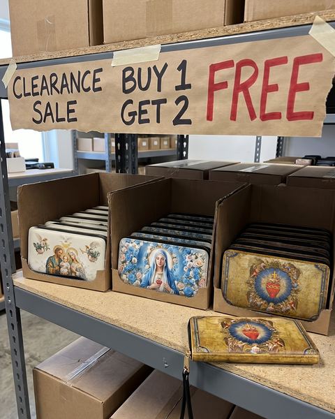 Our warehouse shelf: a hand-written sign that says Clearance sale, buy 1 get 2 free, over bins of Feratia wallets